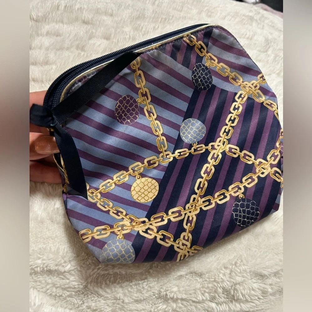 Estée Lauder purple, blue, and gold chain-print cosmetic bag.